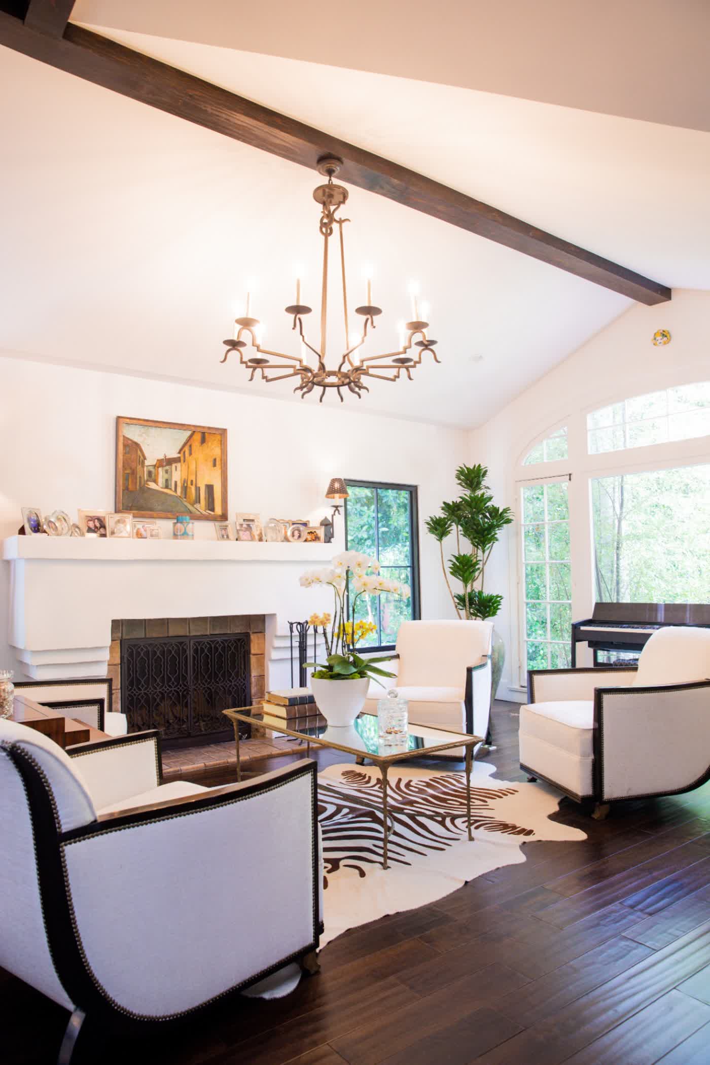 Living room with vaulted ceiling, exposed wood beams, plaster fireplace, and dark hardwood floors